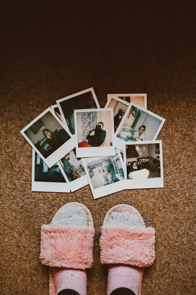 A collection of vintage Polaroids with fuzzy slippers on brown carpet.